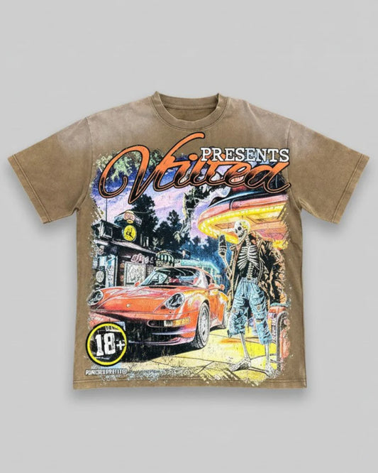 Vtilted "FANTASY" oversized graphic tee in Brown Wash — a vintage Porsche 911 idling under neon at a roadside diner with a skeleton attendant — pure pulp-fiction night