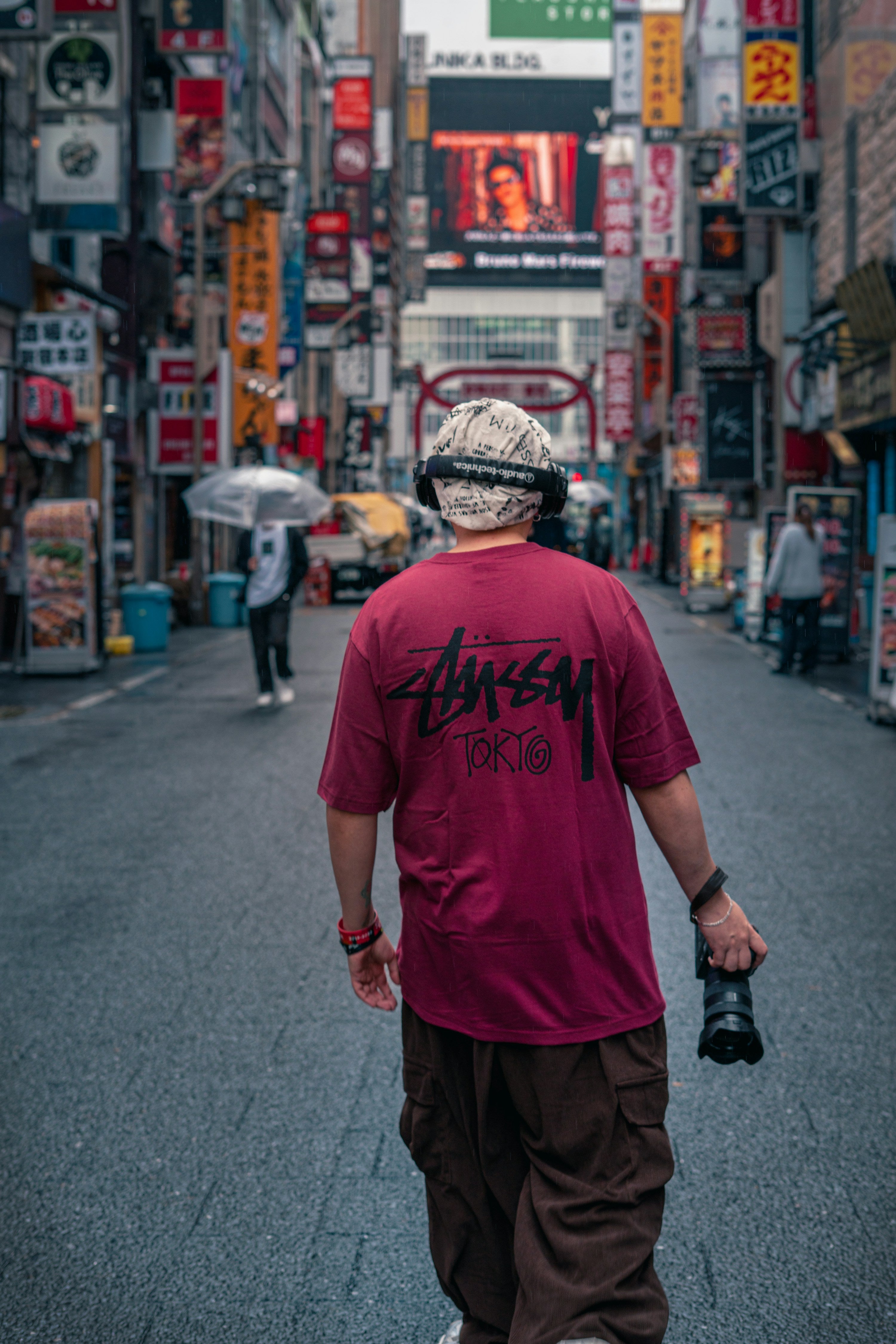 LGND hero — streetwear model walking in Tokyo / Shibuya with graphic tee and cargos