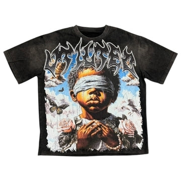 Vtilted "BLINDED" oversized graphic tee in Black Wash — a blindfolded praying child rendered in chiaroscuro oil-painting style, surrounded by storm clouds, roses, and butterflies — a meditation on